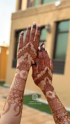 two hands with henna tattoos on their palms