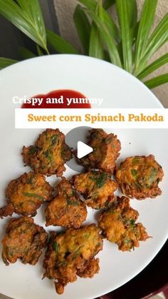 a white plate topped with fried corn spinach patties next to a potted plant