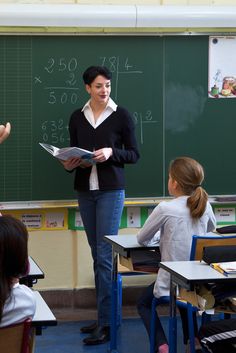 a woman standing in front of a blackboard