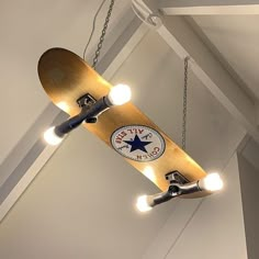 a skateboard hanging from the ceiling with lights on it's sides and wheels