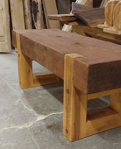 a bench made out of wood sitting on top of a cement floor