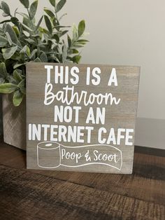 this is a bathroom not an internet cafe sign on a table next to a potted plant