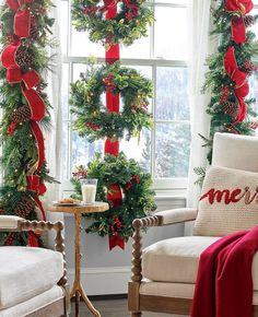 two chairs with christmas wreaths on them in front of a window decorated for the holidays