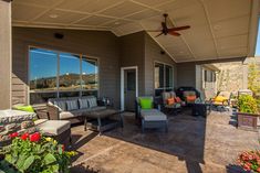 an outdoor patio with furniture and flowers on the ground