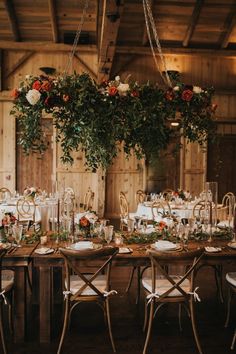 a table set up with flowers and greenery for an outdoor wedding reception at the barn