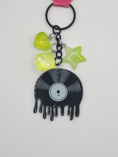 a keychain with a vinyl record and star charms attached to it's side