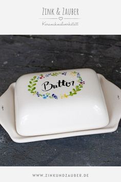 a white plate with the word butter painted on it