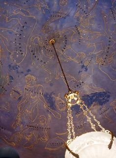 the ceiling is decorated with intricate designs and gold chains hanging from it's sides