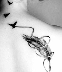 the back of a woman's shoulder with birds flying around it and an arrow tattoo on