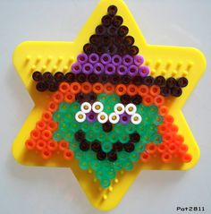 a star shaped beaded decoration with a smiling face