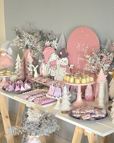 a table filled with pink and white desserts