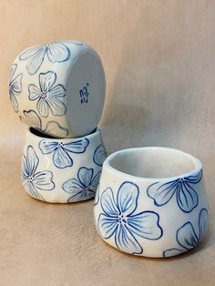 two blue and white flowered bowls sitting on top of each other, one is empty