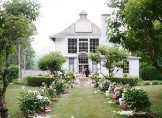 the bride and groom are sitting at their wedding table in front of an elegant white house