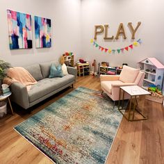 a playroom with couches, tables and toys on the floor in front of a sign that says play