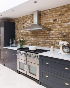 an image of a kitchen with brick wall and stainless steel appliances on the counter top