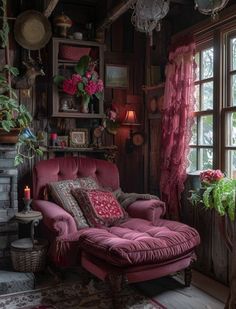 a living room filled with lots of furniture and flowers on the window sill next to a fire place