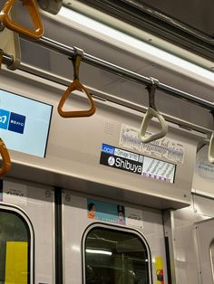 the inside of a subway car with its doors open and some signs hanging from the ceiling