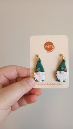 a pair of earrings in the shape of a gnome's hat is being held up