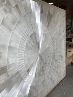 a large piece of art that is made out of plastic and wood, in a workshop