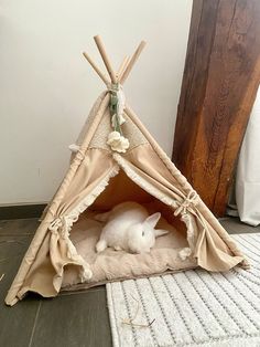 a white bunny in a teepee tent on the floor