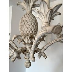 a white chandelier with pineapples on the top and bottom pieces hanging from it