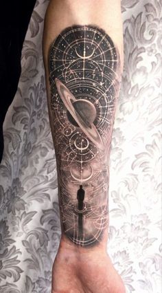 a person with a tattoo on their arm that has an image of saturn and the sun