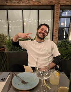 a man sitting at a table in front of a plate with a spoon on it