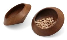 two wooden bowls with nuts in them on a white background