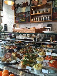 a display case filled with lots of different types of food on plates and in bowls