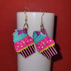 the cupcake earrings are decorated with pink and blue icing