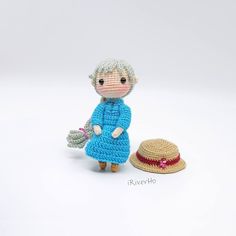 a small crocheted doll next to a straw hat