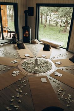 a room with many pieces of paper scattered on the floor and in front of a fire place