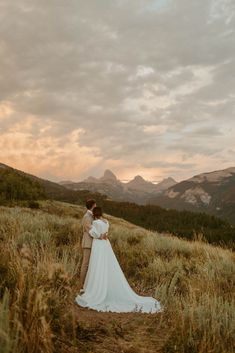 a bride and groom embracing in the mountains