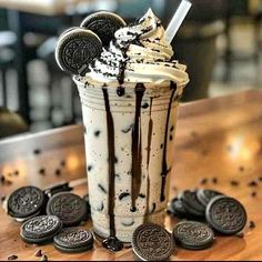 an ice cream sundae with oreo cookies and milkshake on the table