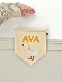 a person is holding a banner with a duck on it and the word ava above it