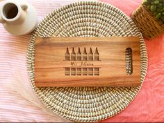 a personalized cutting board on a wicker place mat with a cup and vase