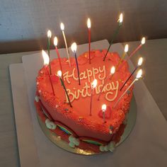 a heart shaped birthday cake with lit candles