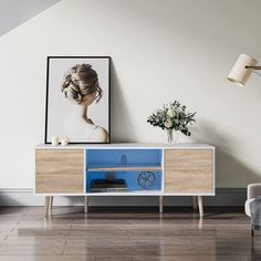 a white and blue cabinet in a living room with flowers on the table next to it