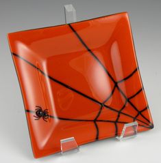 an orange glass plate with a spider on it