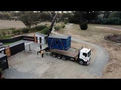 a truck is parked in front of a building with a crane on it's back