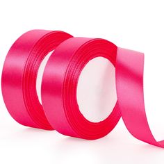 two rolls of bright pink satin ribbon on white background