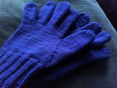 a pair of blue gloves sitting on top of a bed