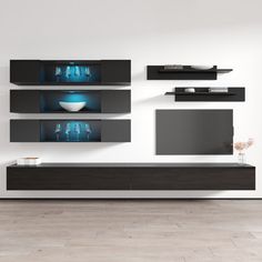 a modern living room with white walls and black entertainment units on the wall, along with floating shelves