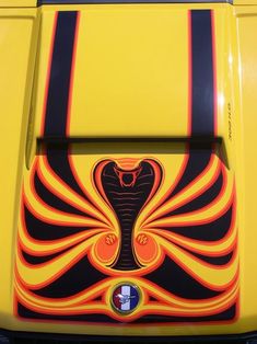 the front end of a yellow bus with an image of a snake on it