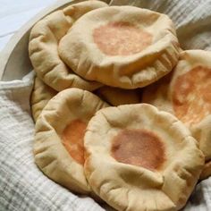 three small pies sitting on top of a white cloth covered table next to each other
