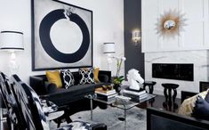 a living room filled with black furniture and white walls in the background is a painting on the wall