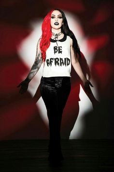 a woman with red hair and makeup wearing a t - shirt that says be afraid