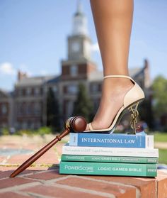 a woman's legs and heels on top of books