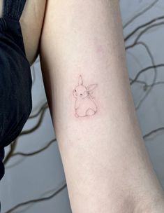 a small tattoo on the arm of a woman with a bunny rabbit in it's ear