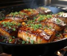 seared scallops are being cooked in a skillet